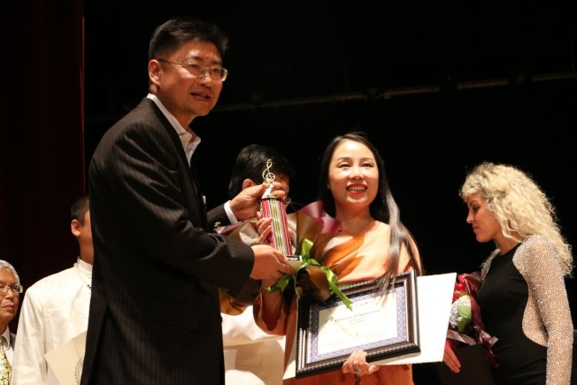 (網路版)
亞美會董事長黃野(左)向李雨兒(中)頒獎狀。(記者俞國梁/攝影)